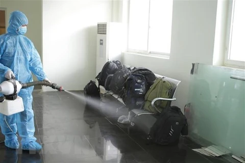 Медицинский работник дезинфицирует багаж людей, незаконно въезжающих во Вьетнам (Источник: ВИA)