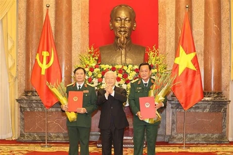 Генеральный секретарь ЦК КПВ, президент Нгуен Фу Чонг (в центре) вручает решения о повышении в должности двум заместителям министра обороны (Фото: ВИА)