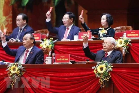 Генеральный секретарь ЦК КПВ и президент Вьетнама Нгуен Фу Чонг (в первом ряду справа) и члены президиума проголосовали за утверждение повестки дня 13-го национального съезда КПВ. (Фото: ВИА)