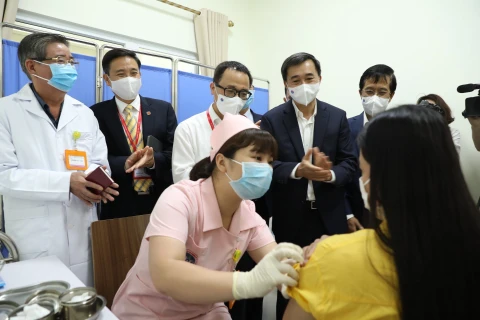 Заместитель министра здравоохранения Чан Ван Тхуан (второй справа) проверяет вакцинацию от COVIVAC на добровольце. (Фото: ВИА)
