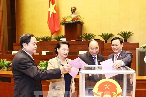 Новоизбранный председатель НС Выонг Динь Хюэ (справа), премьер-министр Нгуен Суан Фук (второй слева) и бывший председатель НС Нгуен Тхи Ким Нган (вторая справа) проголосовали за освобождение от должностей заместителей председателя НС 31 марта. (Фото: ВИА)