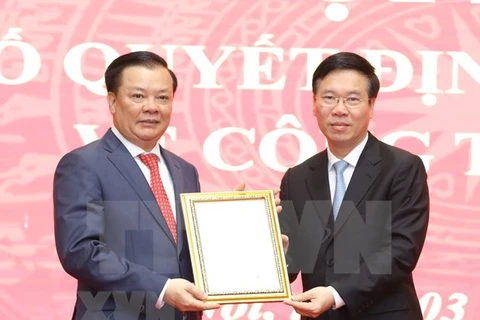 Постоянный член Секретариата ЦК КПВ Во Ван Тхыонг (справа) вручает решение Политбюро секретарью Ханойского партийного комитета Динь Тиен Зунгу. (Фото: ВИА)