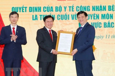Министр здравоохранения Нгуен Тхань Лонг (справа) передает решение о признании Больницы дружбы Нгеана в качестве полноценной больницы в области медицинского осмотра и лечения в северном центральном регионе (Фото: ВИА)