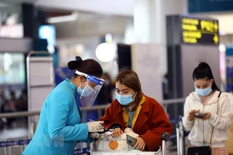 Персонал Vietnam Airlines помогает пассажирам в процедуре электронного декларирования здоровья. (Фото: ВИА)