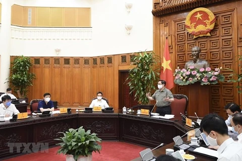 Премьер-министр Фам Минь Тьинь (стоит) на рабочем заседании с Национальным руководящим комитетом по профилактике и борьбе с COVID-19 2 мая (Фото: ВИA)