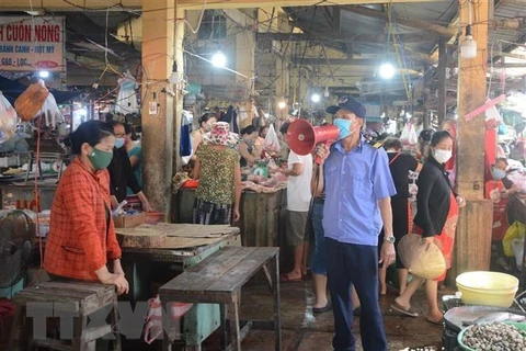 Разъясняются правила по профилактике эпидемии для мелких торговцев на рынке в Дананге. (Фото: Ван Зунг/ВИА)