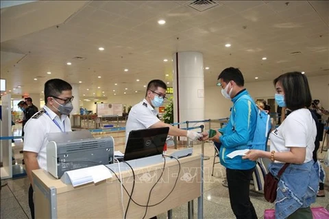 Сотрудники аэропорта проверяют декларацию о состоянии здоровья пассажиров в аэропорту Нойбай (Фото: ВИA)