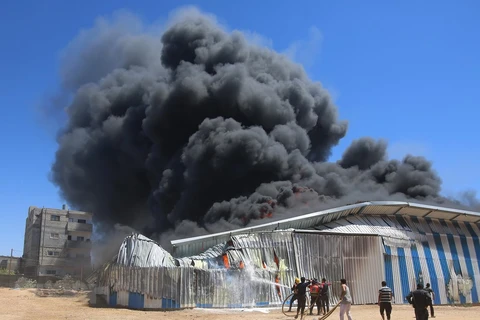 Пожарные пытаются тушить пожар от израильского авиаудара в городе Рафах в секторе Газа. (Фото: Синьхоа/ВИА)