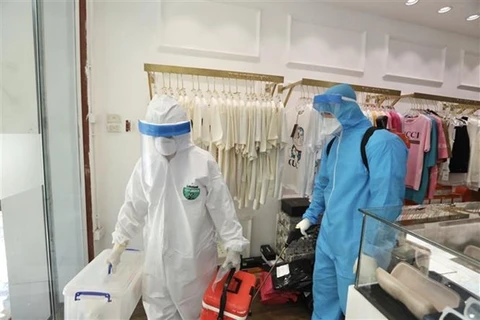 Медицинский персонал в районе Хоан Кием, Ханой, пришел собрать образцы в семье, где член был помещен в карантин в связи с COVID-19. (Фото: Минь Кует / ВИА)