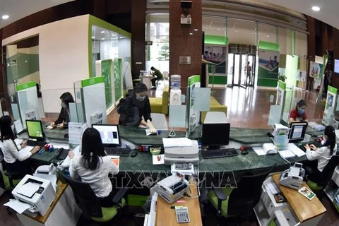 Клиенты совершают операции в головном офисе Акционерного коммерческого банка внешней торговли Вьетнама (Vietcombank) в Ханое. (Фото: ВИА)
