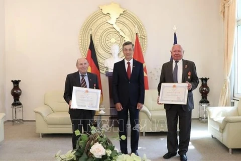 Посол Нгуен Минь Ву (в центре) и двое лауреатов (Фото: ВИА)