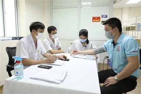 Врачи и волонтер участвуют в 3-м этапе испытания вакцину-кандидат Nano Covax против COVID-19. (Фото: ВИА)
