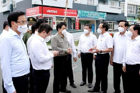 Премьер-министр Фам Минь Тьинь (в коричневой рубашке) инспектирует меры по профилактике и борьбе COVID-19 в Хошимине (Фото: ВИА)