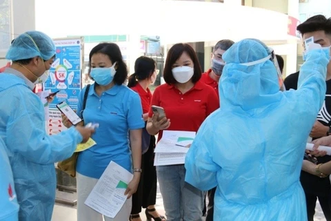 Проверяют медицинскую декларацию и температуру тела работников нефтегазовой отрасли перед входом в зону вакцинации 