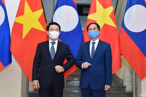 Министр иностранных дел Вьетнама Буй Тхань Шон (справа) и его лаосский коллега Салеумксай Коммасит. (Фото: ВИА)