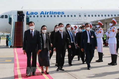 Встреча генерального секретаря Лаосской партии и президента Лаоса Тонглун Сисулит (слева) в международном аэропорту Нойбай (Фото: ВИА)
