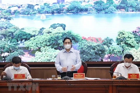Премьер-министр Фам Минь Тьинь (в центре) выступает на встрече с властями Ханоя (Фото: ВИА)