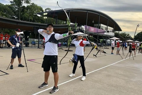 Спортсмены До Тхи Ань Нгует и Нгуен Хоанг Фи Ву тренируются в стрельбе из лука в Токио. (Фото: ВИА)