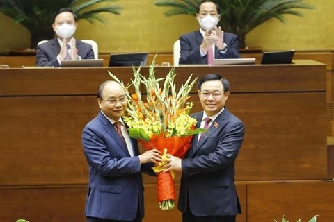Председатель НС Выонг Динь Хюэ (справа) поздравляет Нгуен Суан Фука с избранием на пост президента Вьетнама. (Фото: ВИА)