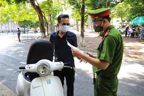 При выходе на улицы жители Ханоя обязаны предъявить пропуск, выданный работодателями. (Фото: ВИА)