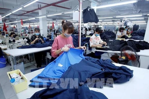 Рабочие производят швейные изделия на акционерном предприятии по пошиву одежды Hung Long в уезде Михао провинции Хынгйен. (Фото: ВИА)
