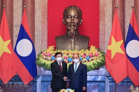 Президент Нгуен Суан Фук (справа) приветствует генерального секретаря Центрального комитета народно-революционной партии Лаоса, президента Лаоса Тонглуна Сисулита в Ханое 29 июня 2021 года (Фото: ВИA)