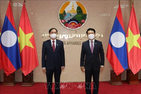Министр иностранных дел Вьетнама Буй Тхань Шон (слева) и министр иностранных дел Лаоса Салымсай Коммаситх. (Фото: опубликовано ВИА)