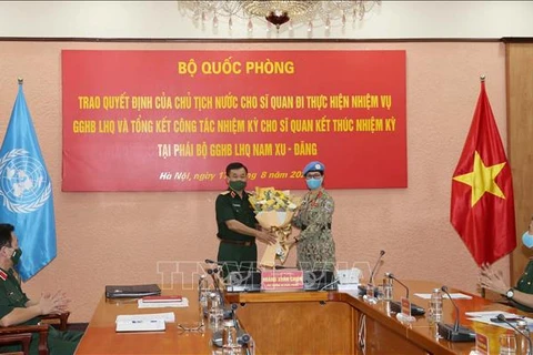 Генерал-полковник Хоанг Суан Тьиен вручает цветы подполковнику Нгуен Тхи Минь Фыонг, первой женщине-офицеру Вьетнама, дежурившей в Миссии ООН в Республике Южный Судан (МООНЮС) в 2019-2020 гг. в качестве военного наблюдателя. (Фото: ВИА)