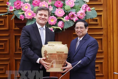 Премьер-министр Фам Минь Тьинь дарит послу Войцеху Гервелю сувениры. (Фото: Зыонг Жанг / ВИА)