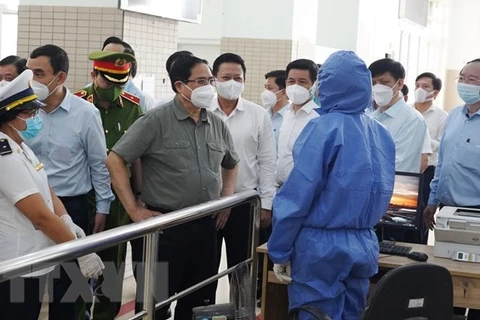 Премьер-министр Фам Минь Тьинь инспектирует меры по профилактике и борьбе с COVID-19 в городе Тхудык. (Фото: ВИА)