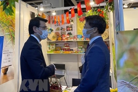 Директор департамента экономического и торгового развития Гонконга Цю Тэнхуа (слева) и генеральный консул Вьетнама в Гонконге Фам Бинь Дам у вьетнамского выставочного стенда. (Фото: ВИА)