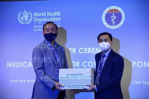 Представитель ВОЗ во Вьетнаме д-р Кидонг Пак (слева) передает медицинские принадлежности заместителю министра здравоохранения профессору д-ру Чан Ван Тхуану. (Фото: Минздрав)