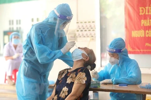 Медицинский персонал берет образцы для тестирования на COVID-19 у людей в квартале Фохюэ (район Хайбачынг, Ханой). (Фото: Минь Кует / ВИА)