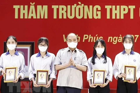 Президент Нгуен Суан Фук вручает подарки ученикам. (Фото: Тхонг Нят/ВИА)
