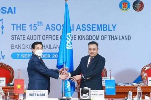 Государственный аудитор Вьетнама Чан Ши Тхань (справа) вручил флаг для передачи полномочие председателя ASOSAI Генеральному государственному аудитору Таиланда. (Фото: ВИА)
