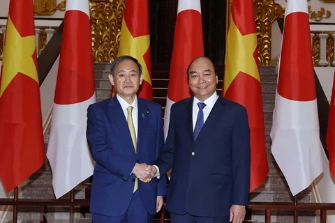 Премьер-министр Нгуен Суан Фук (справа) пожимает руку премьер-министру Японии Суга Йошихиде во время визита последнего во Вьетнам в октябре 2020 года (Фото: ВИА)