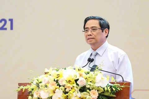 Премьер-министр Фам Минь Тьинь выступает на конференции. (Фото: ВИА)