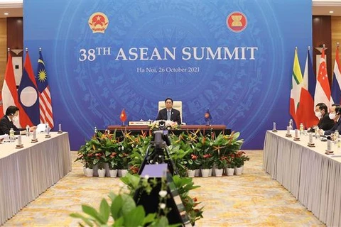 Премьер-министр Фам Минь Тьинь принимает участие в 38-м саммите АСЕАН посредством ханойского телемоста. (Фото ВИА)