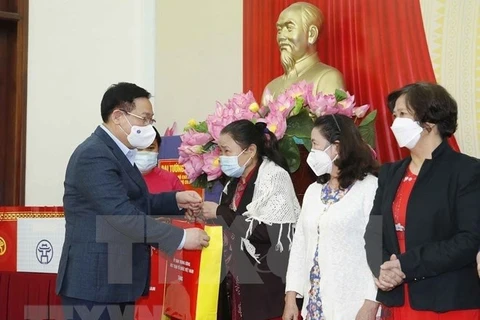 Председатель НС Выонг Динь Хюэ вручает подарки некоторым местным семьям, внесшим выдающийся вклад в развитие местного сообщества. (Фото: ВИА) 