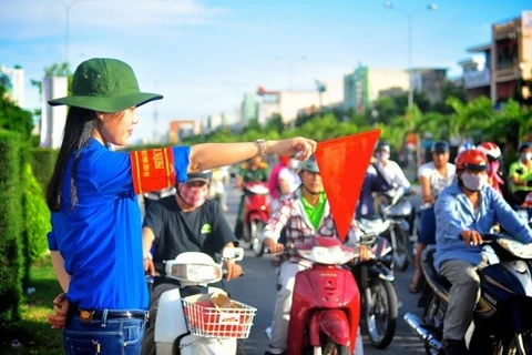 Волонтер помогает регулировать дорожное движение. (Фото doanthanhnien.vn) 