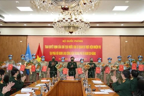 Генерал-полковник Хоанг Суан Чиен, заместитель министра национальной обороны (седьмой слева) представляет решение 12 офицерам. (Фото: ВИА) 