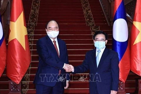 Президент государства Нгуен Суан Фук и премьер-министр Лаоса Фанкхам Випхаван во время официального дружественного визита президента в Лаос в августе этого года. (Фото: ВИА)
