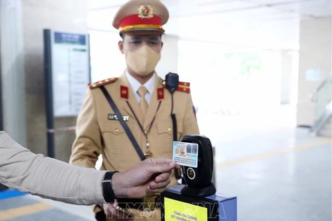 Люди используют удостоверение о личности с чипом для сканирования QR-кода на наземных железнодорожной линии Ханоя. (Фото: ВИА)