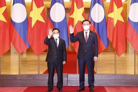 Председатель НС Выонг Динь Хюэ (справа) и премьер-министр Лаоса Пханхам Випхаван позируют фотографу перед встречей в Ханое 8 января (Фото: ВИА) 