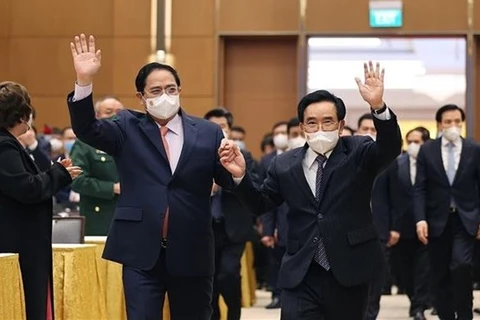 Премьер-министр Фам Минь Тьинь и его лаосский коллега Пханхам Випхаван встречаются с представителями деловых кругов двух стран (Фото: ВИА) 