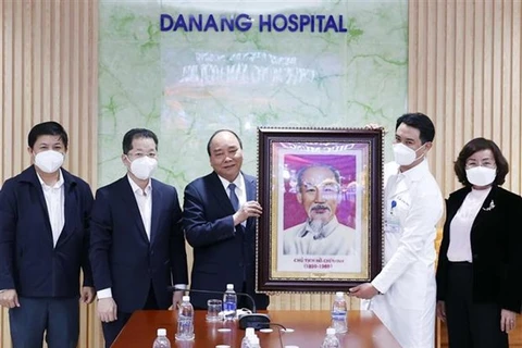 Президент Нгуен Суан Фук (третий слева) вручает портрет президента Хо Ши Мина больнице Дананга. (Фото: ВИА)