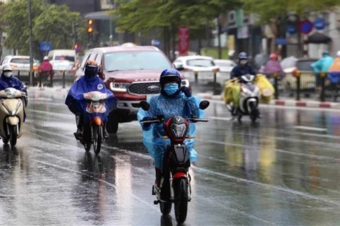 Люди в теплой одежде едут под дождем (Фото: ВИА) 