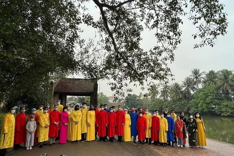 Иностранные дипломаты в «аозай» (традиционный костюм Вьетнама) позируют фотографу во время посещения деревни Дыонглам 23 января (Фото: ВИА)