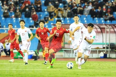 Нгуен Тиен Линь (номер 22) борется за мяч во время матча против Китая на стадионе Мидинь в Ханое 1 февраля. (Фото: ВИА)