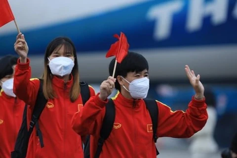 Футболисты машут приветствующим их людям в международном аэропорту Нойбай в Ханое 10 февраля (Фото: ВИА)